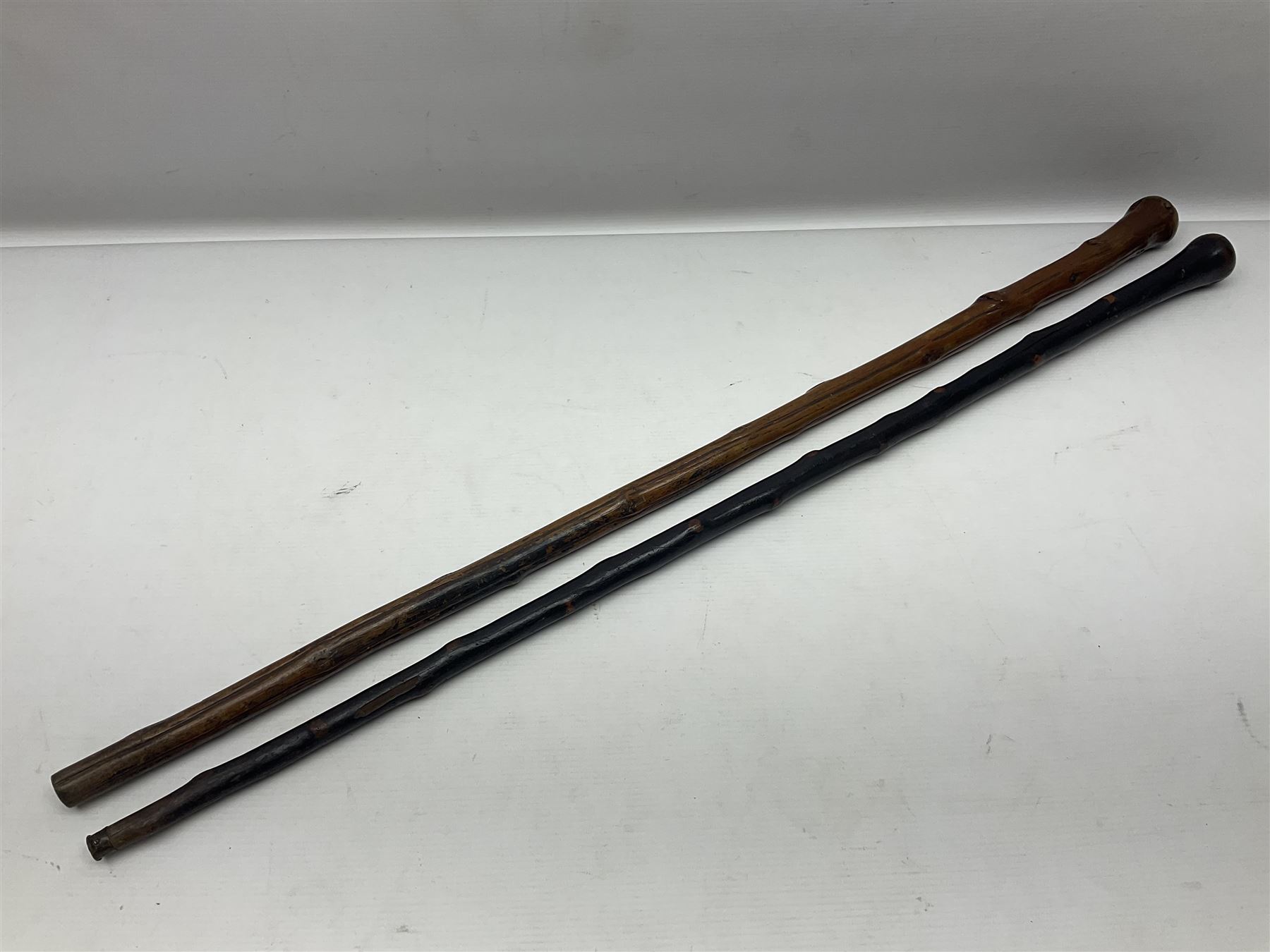 Two wooden walking sticks, both with comparts that would have housed horse measures, H88cm