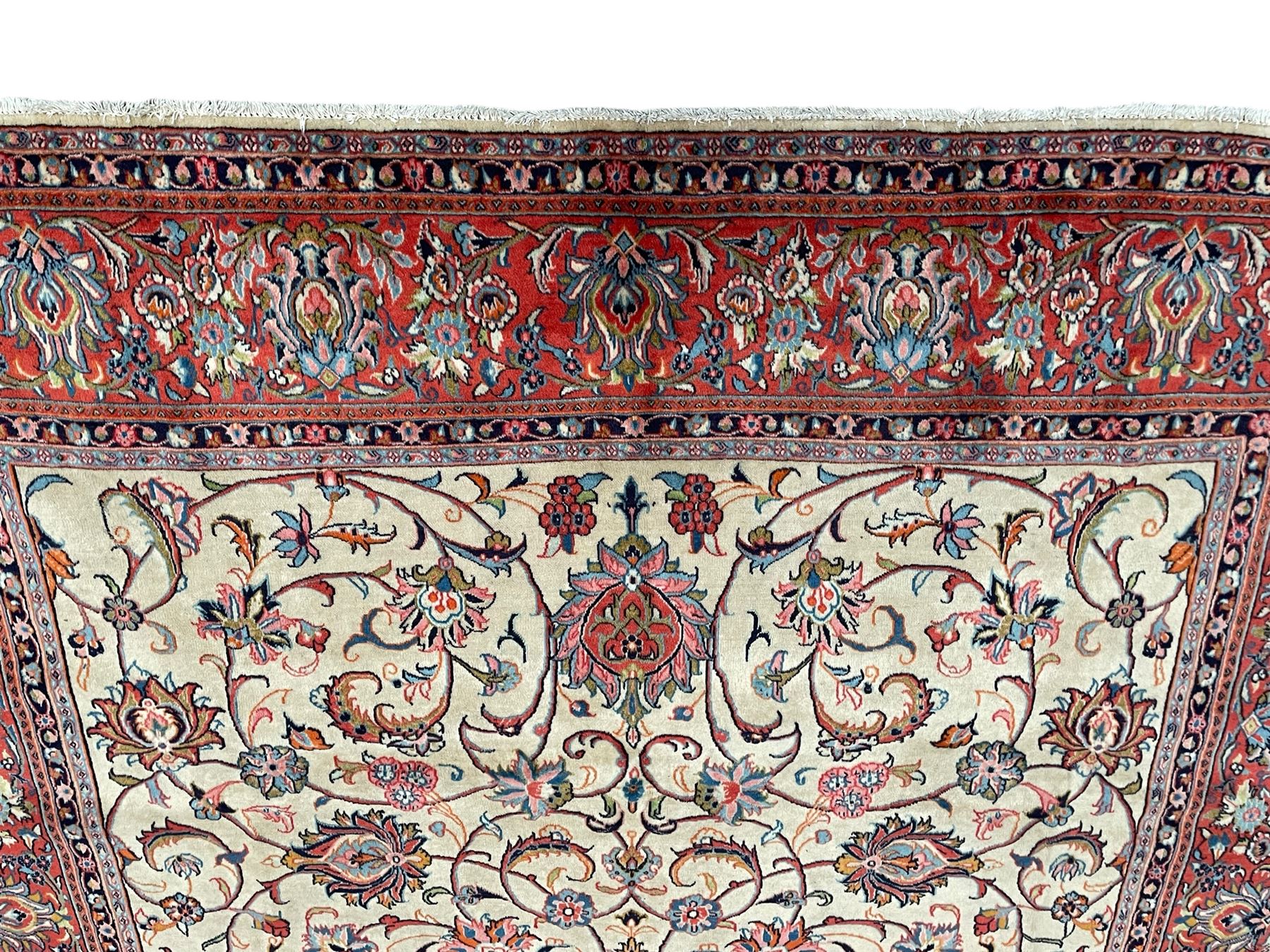 Persian Sarough ivory ground rug, the field decorated with curled leafy branches and palmettes, crimson ground border decorated with further palmettes and floral sprays, within guard stripes 