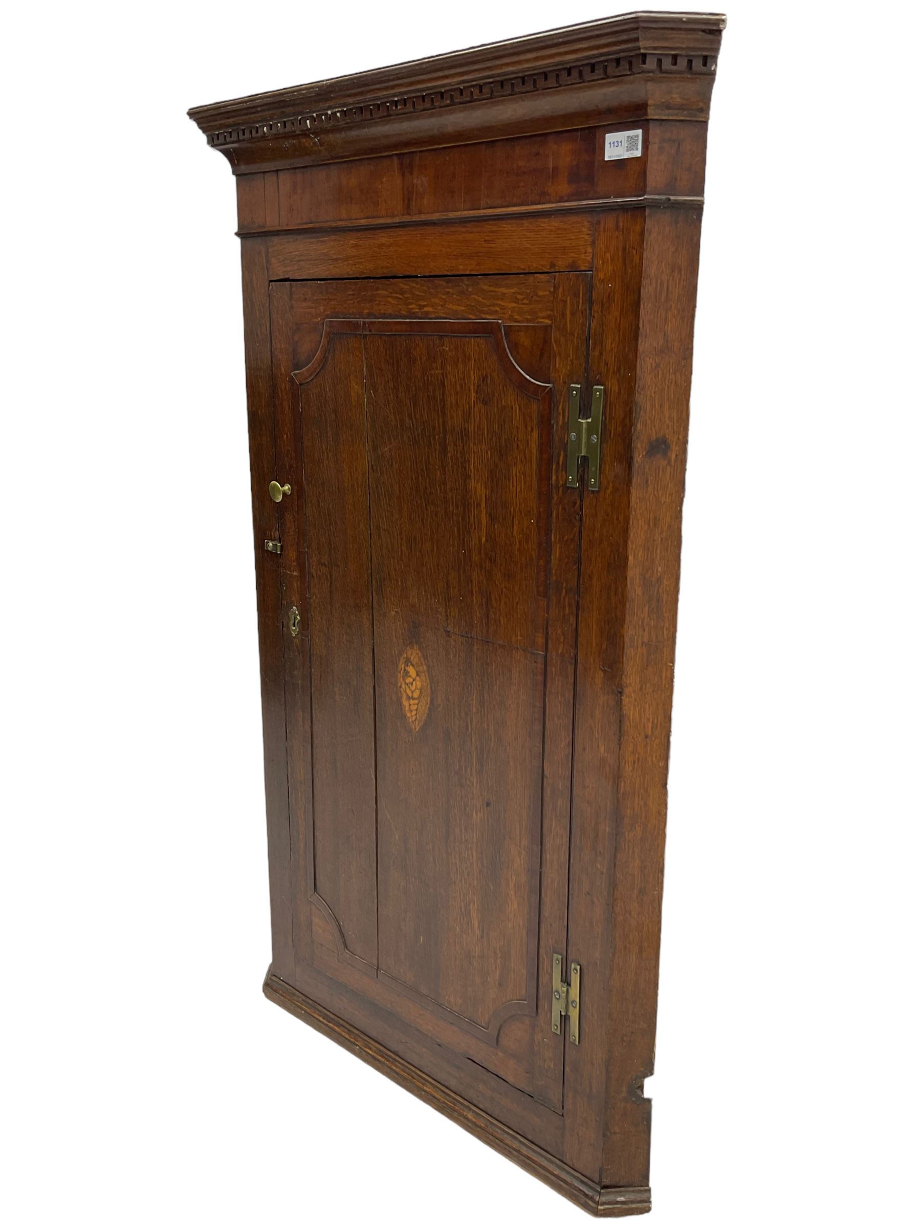 George III oak and mahogany wall hanging corner cupboard, single door decorated with central inlaid shell motif enclosing three shelves