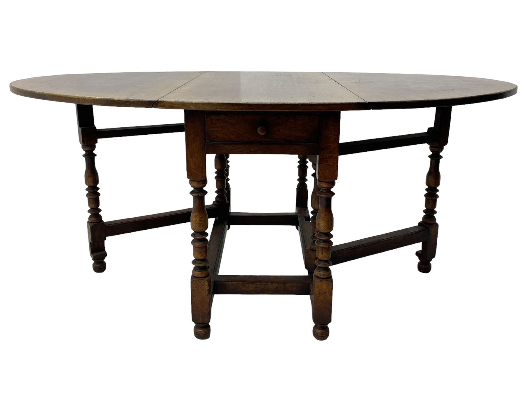 18th century oak dining table, oval drop-leaf top on gate-leg action base, turned supports united by turned stretchers, fitted with single end drawer