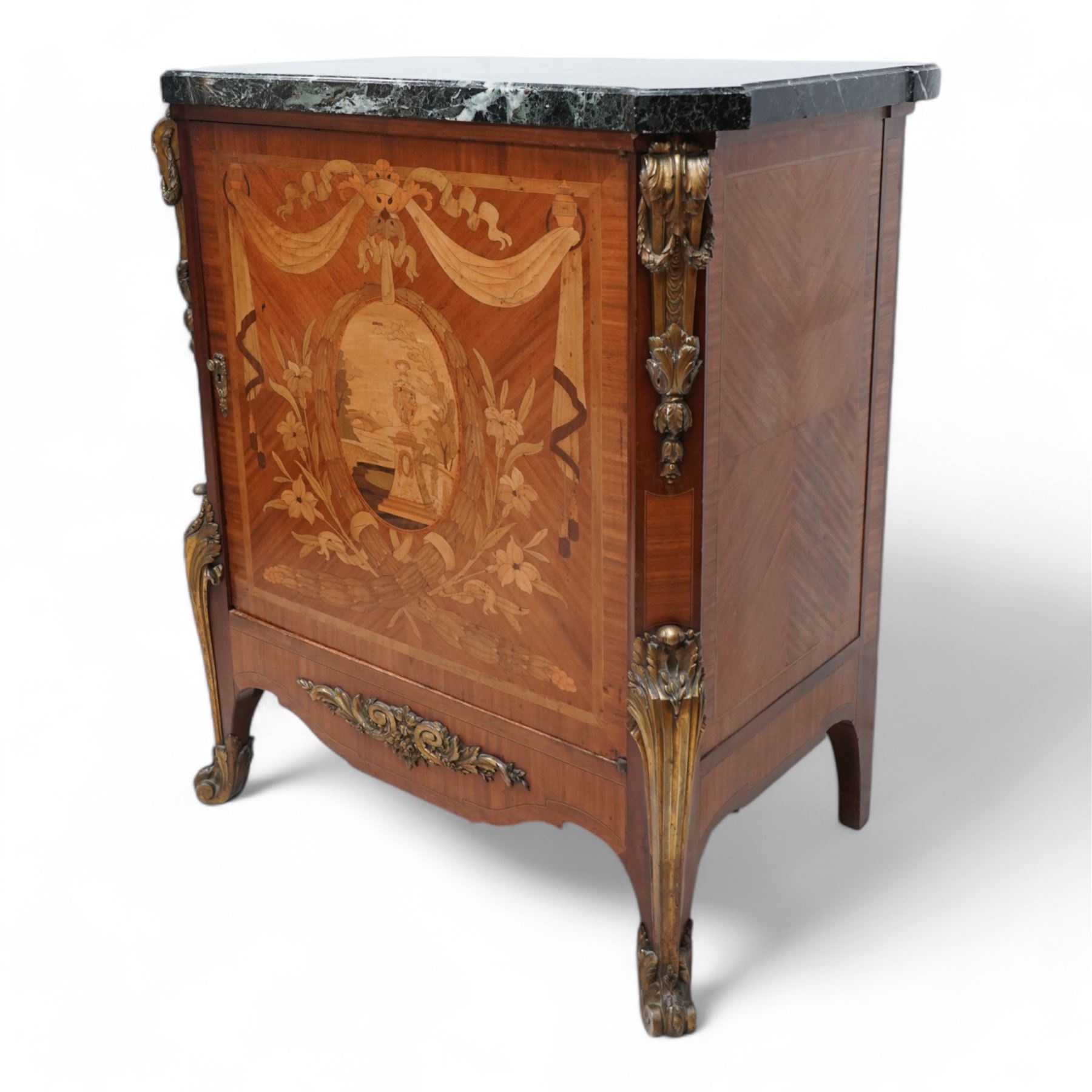 20th century French Kingwood and gilt metal mounted side cabinet, moulded green variegated marble top over single cupboard, enclosed by marquetry inlaid single door, the oval panel depicting urn and bridge in garden landscape, surrounded by fruiting laurel wreath and enclosed by draped linen swags, decorated with trailing leafy branches and flower heads, canted corners with scroll and acanthus leaf cast mounts decorated with laurel swags, curled acanthus leaf lower mounts terminating to scrolled terminal caps, the interior fitted with single shelf 