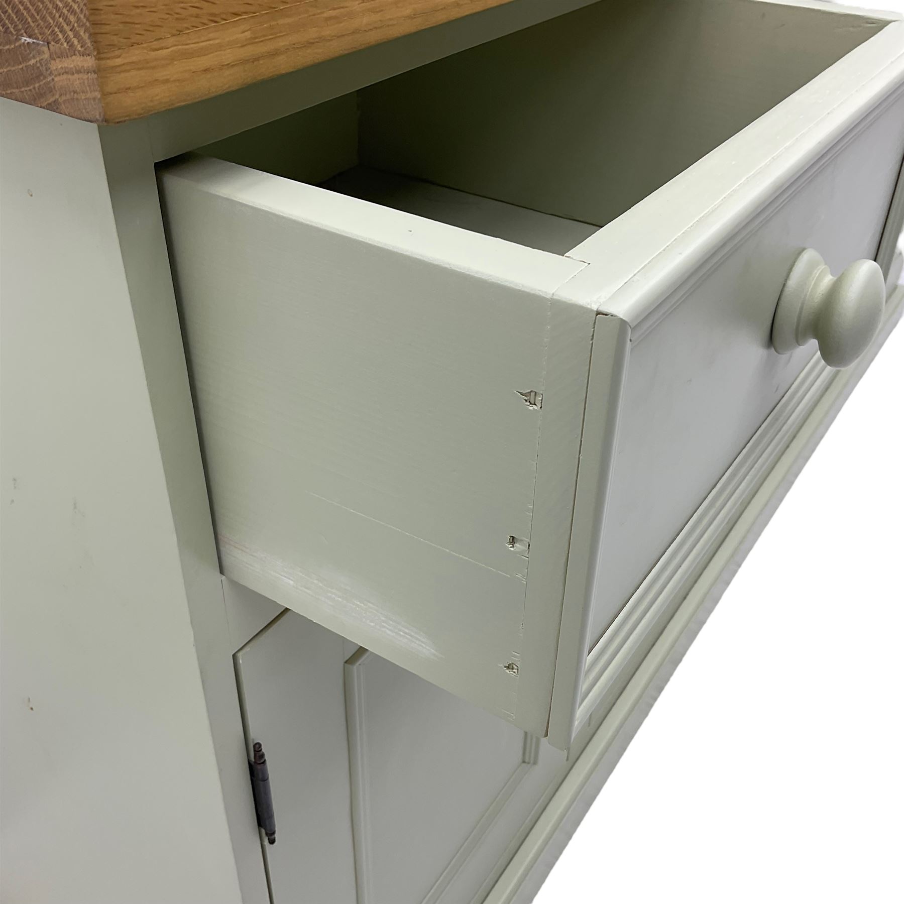 Painted kitchen dresser, projecting moulded cornice over central glazed display doors and flanking panelled cupboard doors, polished oak rectangular top over four drawers and four cupboards, on moulded plinth base, in laurel green paint finish 