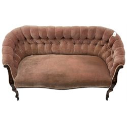 Late 19th century mahogany framed two-seat sofa, upholstered in buttoned pink fabric, on cabriole front supports, on castors 