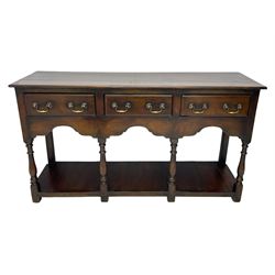 Georgian design oak dresser base, rectangular three plank top over three drawers and shaped apron, moulded drawer fronts with brass swan neck handles and circular plates, turned supports on panelled pot board base