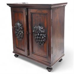 19th century rosewood spice cabinet, moulded cornice over two panelled doors decorated with fruiting foliage carved mounts, the interior fitted with a combination of small drawers, on turned feet