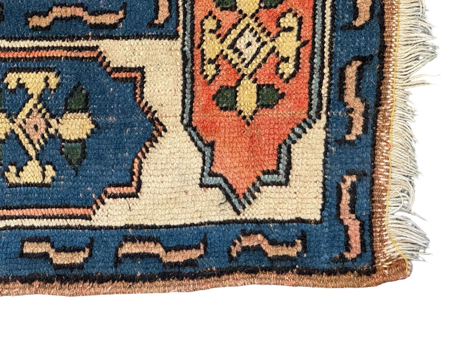 Turkish indigo ground rug, the shaped central field decorated with a central geometric stylised plant motif, enclosed with a guarded border decorated with contrasting motifs 