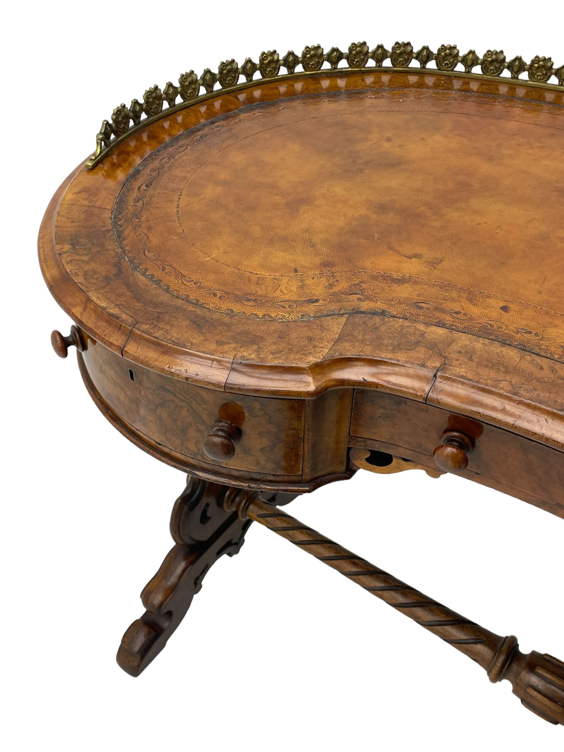 Victorian walnut kidney-shaped writing desk, moulded top with floral cast brass gallery and inset leather writing surface, fitted with three frieze drawers with turned handles, shaped and pierced end supports on raised platforms terminating to splayed feet, united by twist turned and lobe carved stretcher, brass and ceramic castors 