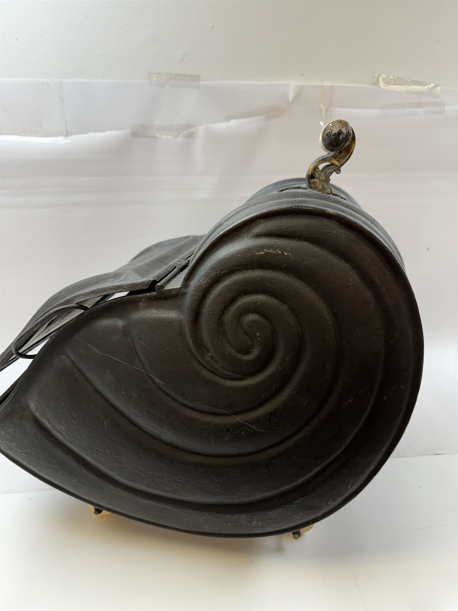 Victorian black matte metal coal scuttle, in the form of a nautilus shell, with ceramic wheels and handle, H47cm