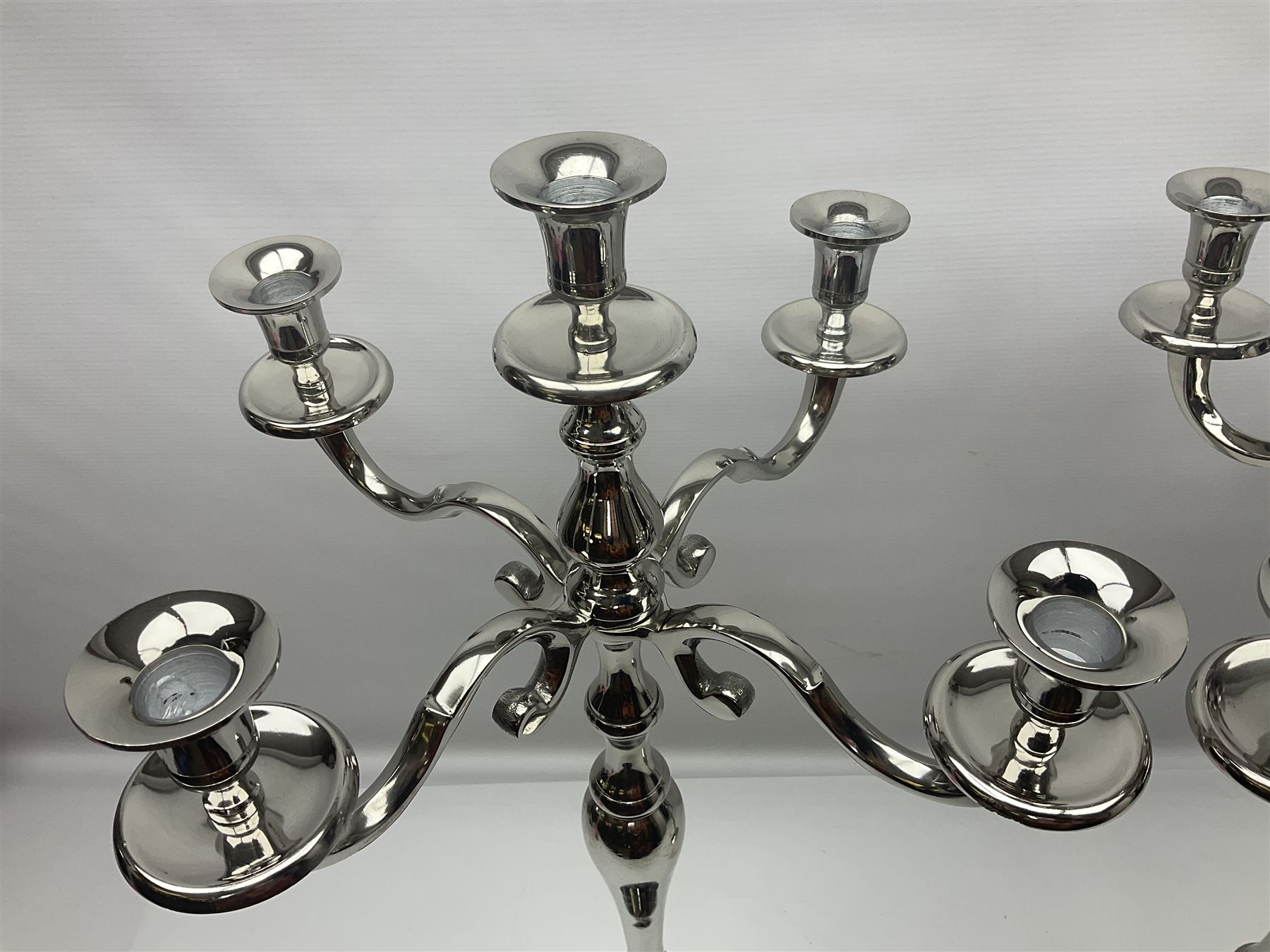 Pair of four branch candelabras, urn-shaped nozzles raised upon scroll branches supported from tapering central stem, with circular base, H70cm