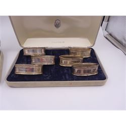 Two sets of six modern silver napkin rings, each of oval form, with Greek key decoration, hallmarked Ari D Norman, London 1986, both in fitted cases