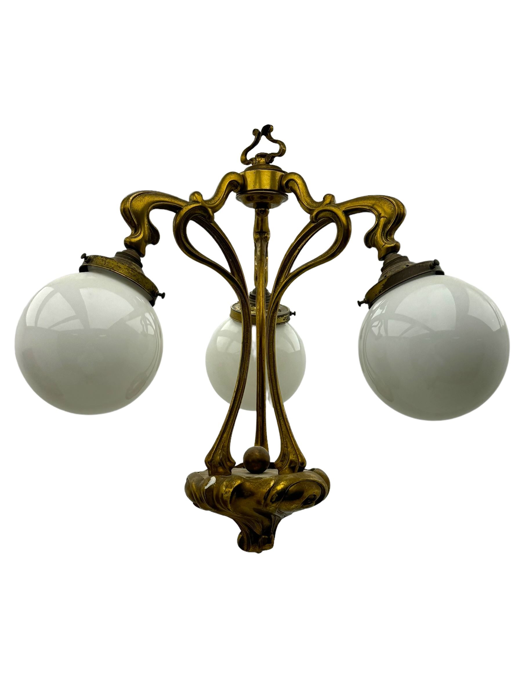 Pair of Art Nouveau design gilt metal ceiling lights, each with three stems connecting glass dome