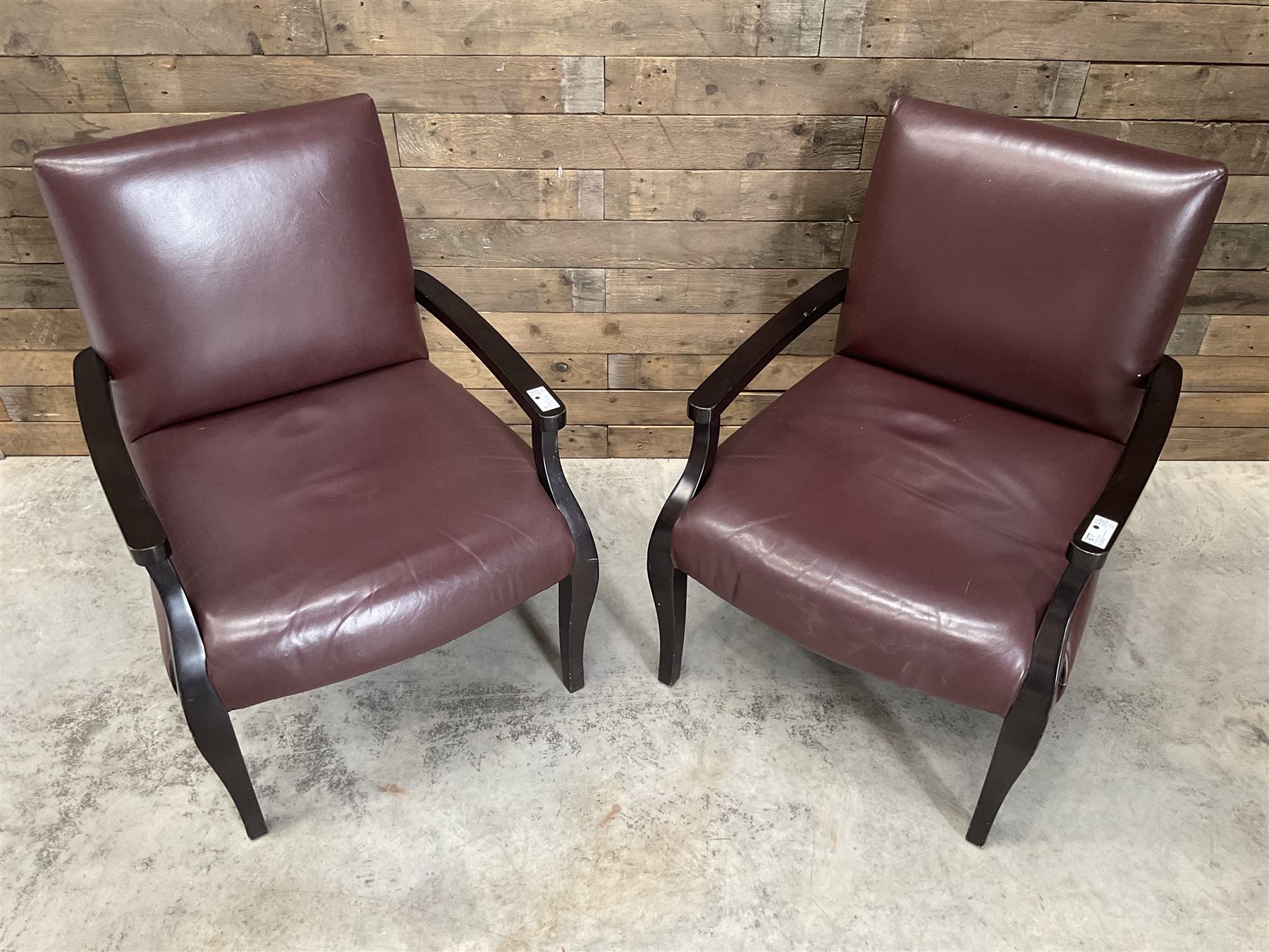 Two rosewood framed armchairs, upholstered in brown leather