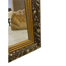 Large rectangular gilt framed wall mirror, decorated with trailing leafy branches and flowerheads, bevelled glass plate 