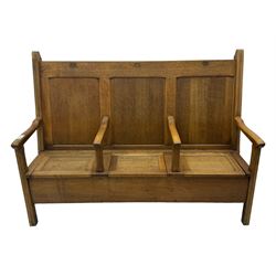 Early 20th century oak settle, featuring a high back with three panel sections and hinged lids, the bench seat divided into three sections, each with its own armrests, supported by square legs