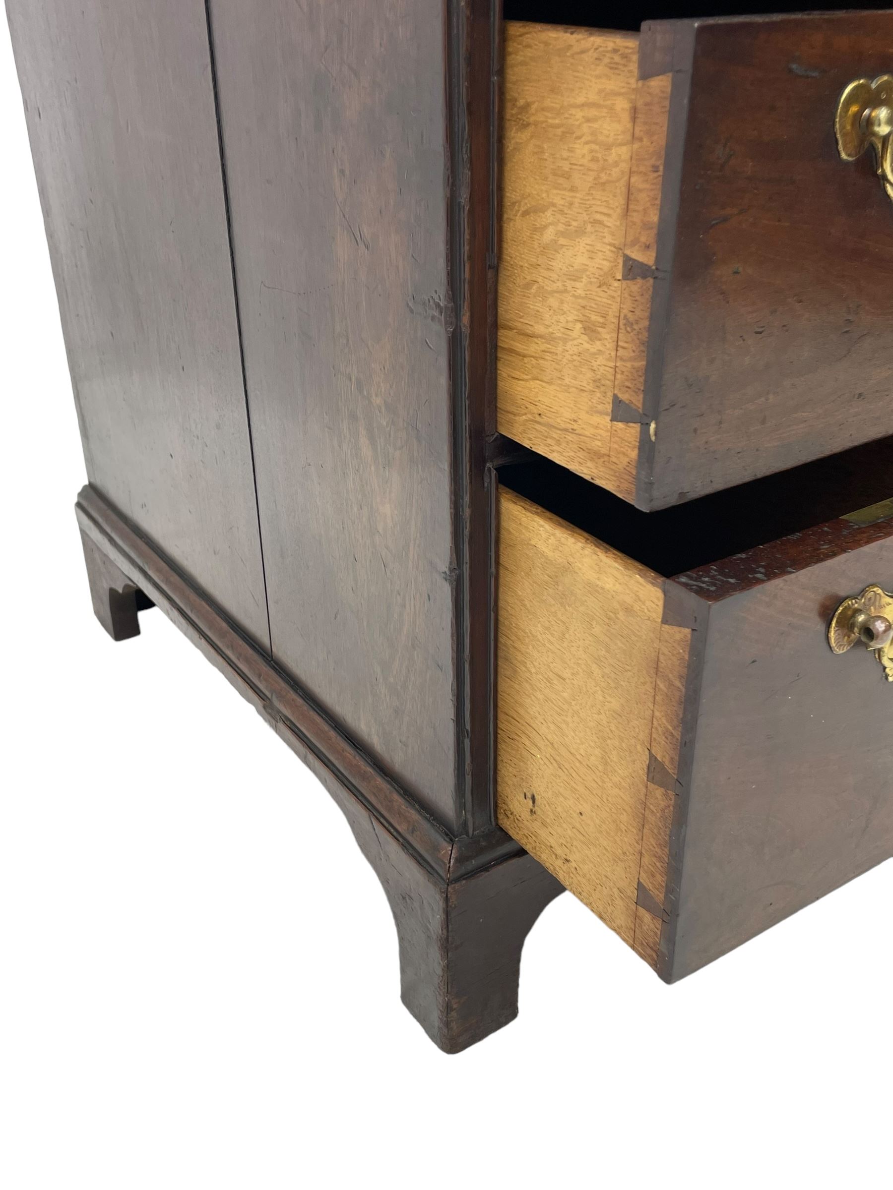 George III mahogany kneehole desk, moulded rectangular top over one long drawer, six short drawers and recessed panelled cupboard, cock-bead moulded frame, fitted with shaped brass handle plates with engraved decoration, on bracket feet 