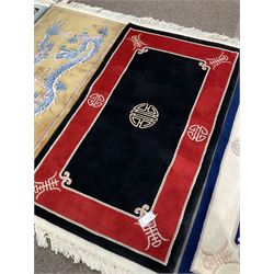 Collection of four Chinese washed woollen rugs - blue ground (153cm x 92cm); red and black ground (156cm x 94cm); light blue ground (138cm x 70cm); gold ground (153cm x 77cm)