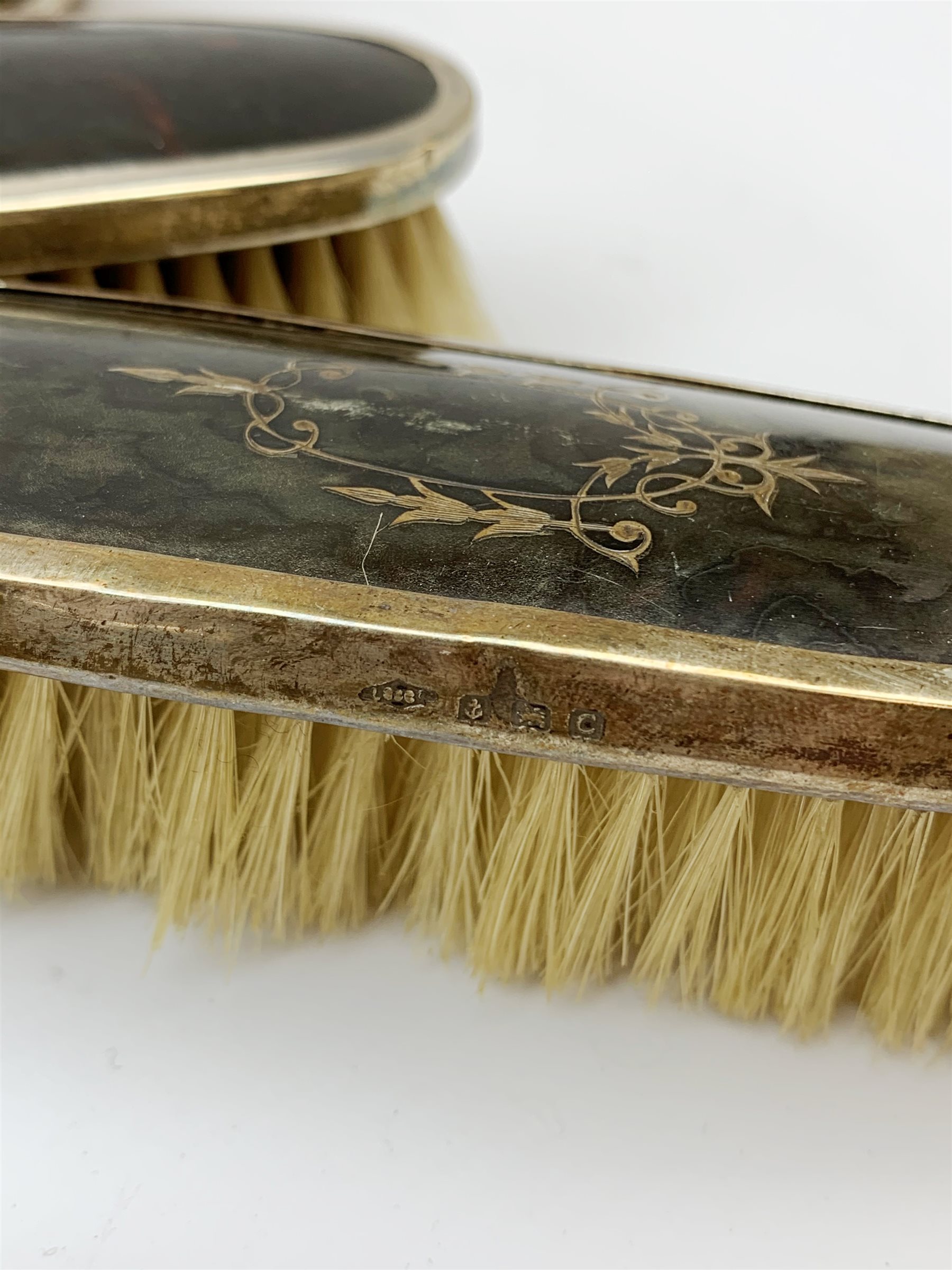 A silver mounted faux tortoiseshell dressing table set, comprising hand held mirror, two hair brushes, and two clothes brushes, each with inlaid swag to the back, hallmarked Lionel Smith & Co, Birmingham 1927, plus a silver mounted clothes brush with engine turned decoration and monogramed plaque, hallmarked William Neale & Son Ltd, Birmingham 1929, pair of silver plate on copper bottle coasters, cased set of fish servers, and cased set of fish eaters and servers, the knife blades marked Mappin & Webb. 