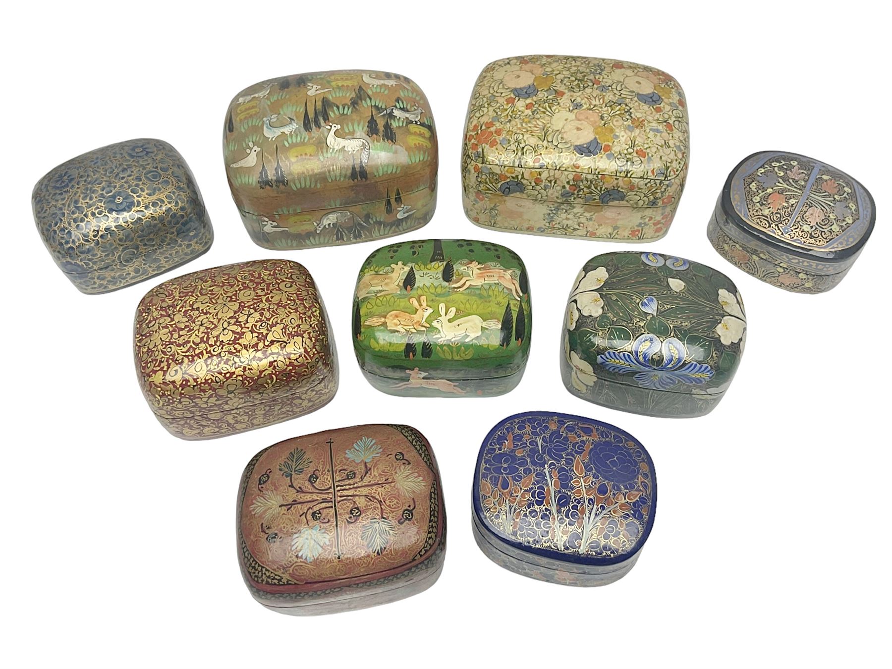 Nine lacquered boxes, all rectangular form, including russian examples decorated with animals within a stylized landscapes and example with flower decoration, largest H7cm, L11cm