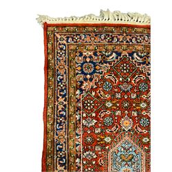 Small crimson ground rug, the extending lozenge field decorated with Herati motifs and flower heads, repeating guarded border