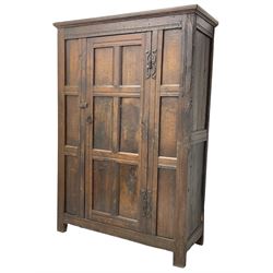 17th century and later oak hall cupboard, panelled front and sides with moulded frame, enclosed by single door with wrought metal hinges and handle, the interior fitted with hooks, on stile supports 