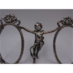 Edwardian silver double photograph frame by Berthold Herrman Muller, the oval frames each with ribbon surmount and supported by a central cherub, H8.5cm