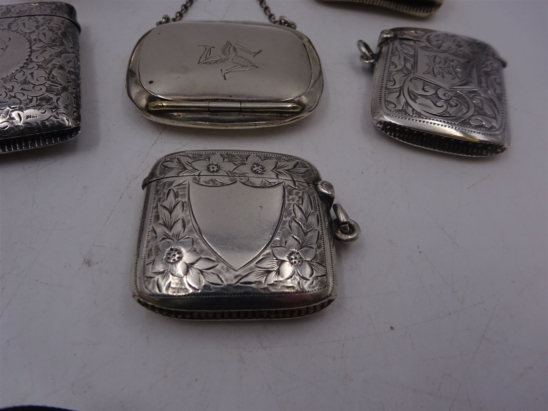 1920s silver miniature purse, engraved with triskelion symbol to hinged cover, hallmarked Adie & Lovekin Ltd, Birmingham 1920, together with five early 20th century silver vesta cases, all of typical form, engraved with foliate and scrolling details, all hallmarked