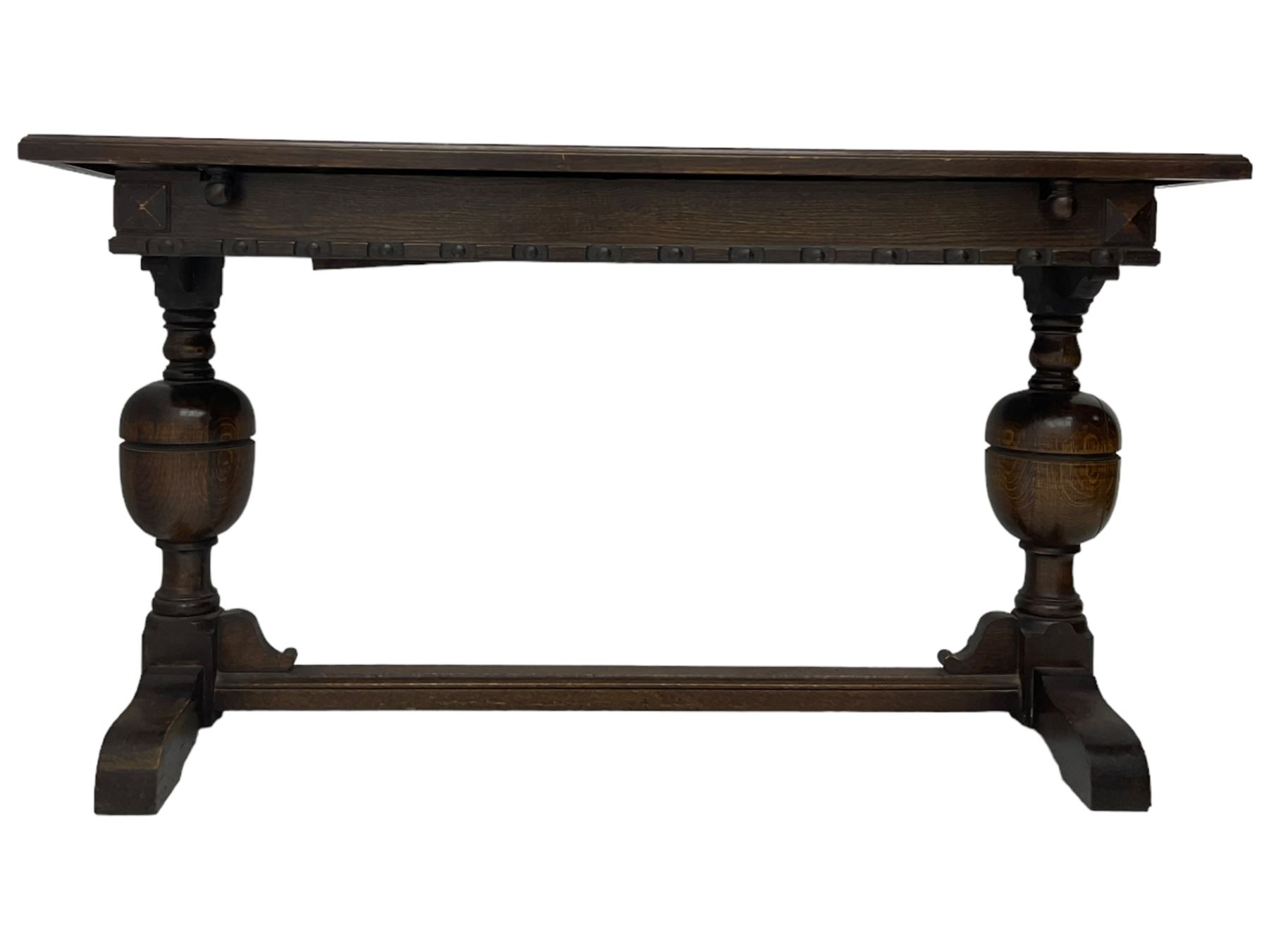 Early 20th century oak extending table, moulded rectangular top, pull-out action with fold-out leaf, on turned cup and cover pedestals and sledge feet, united by moulded stretcher 