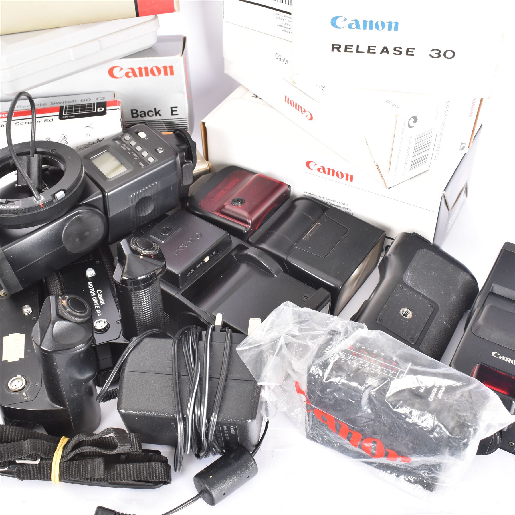 Collection of Canon camera accessories, predominantly for SLR cameras, including flashes, motor drives, quartz date back grips, filters, etc, mostly boxed or cased 