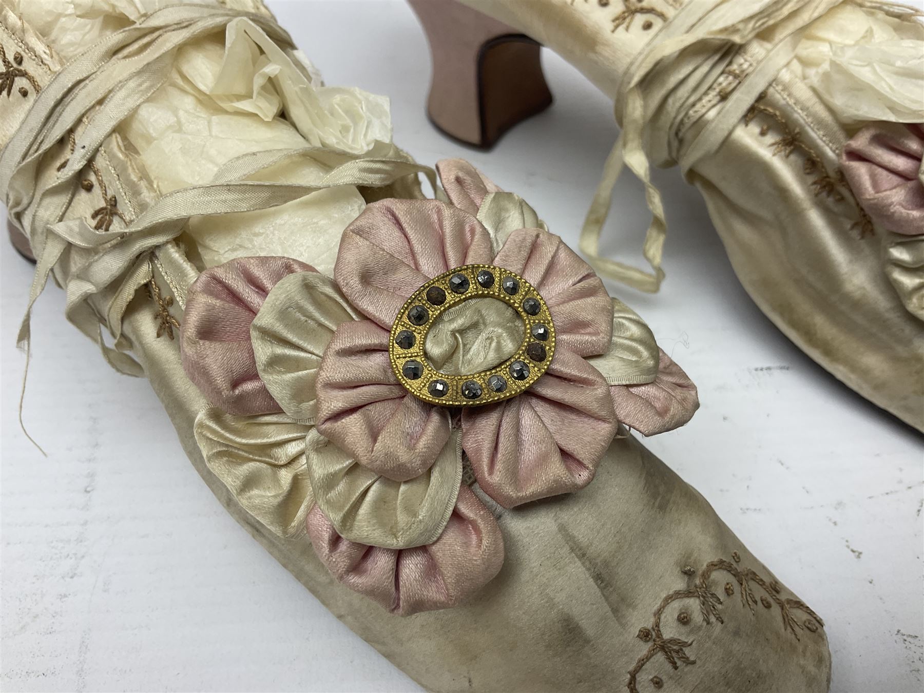 Pair of 19th century ivory silk satin ladies shoes, with rosette to the vamp, with pink silk satin heel, L23cm