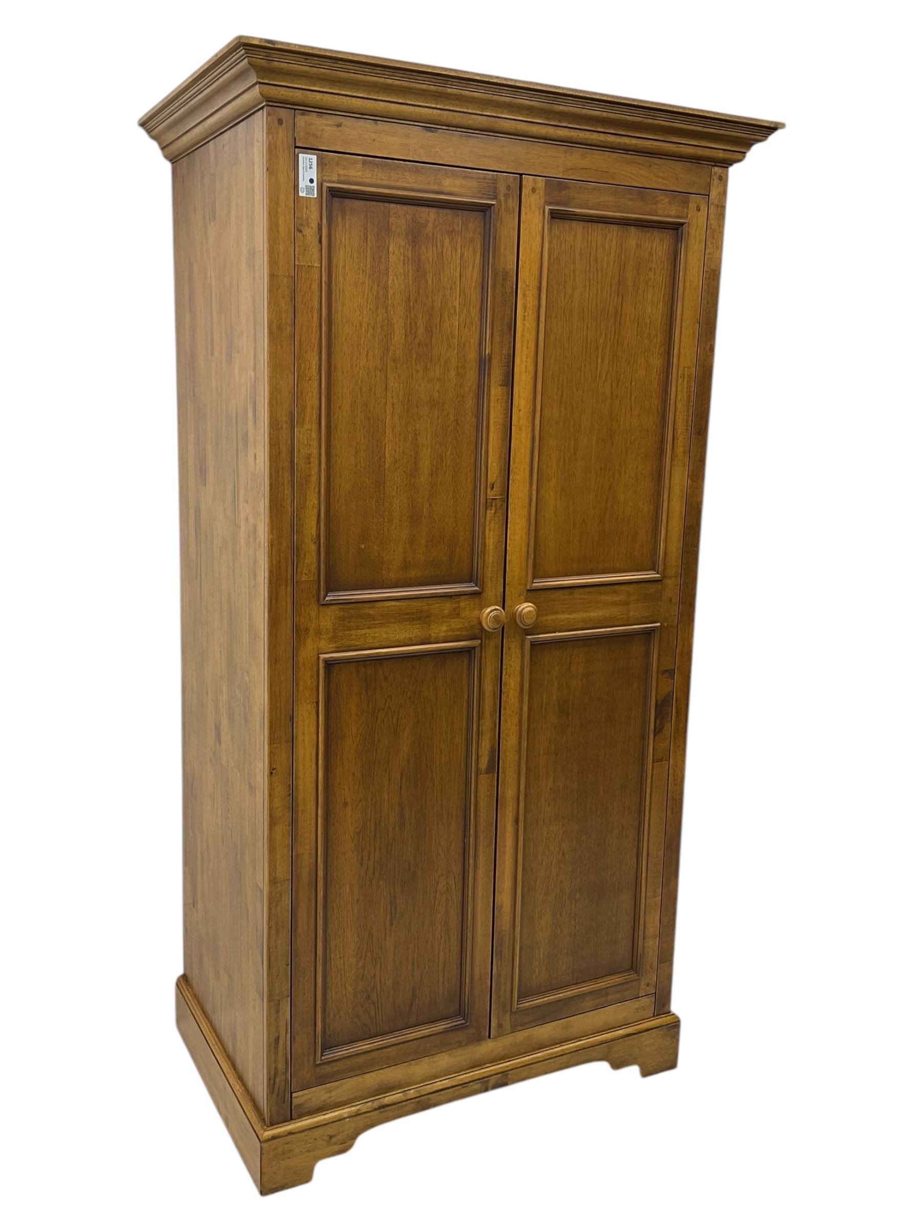 Hardwood double wardrobe, enclosed by two panelled doors, on bracket feet 