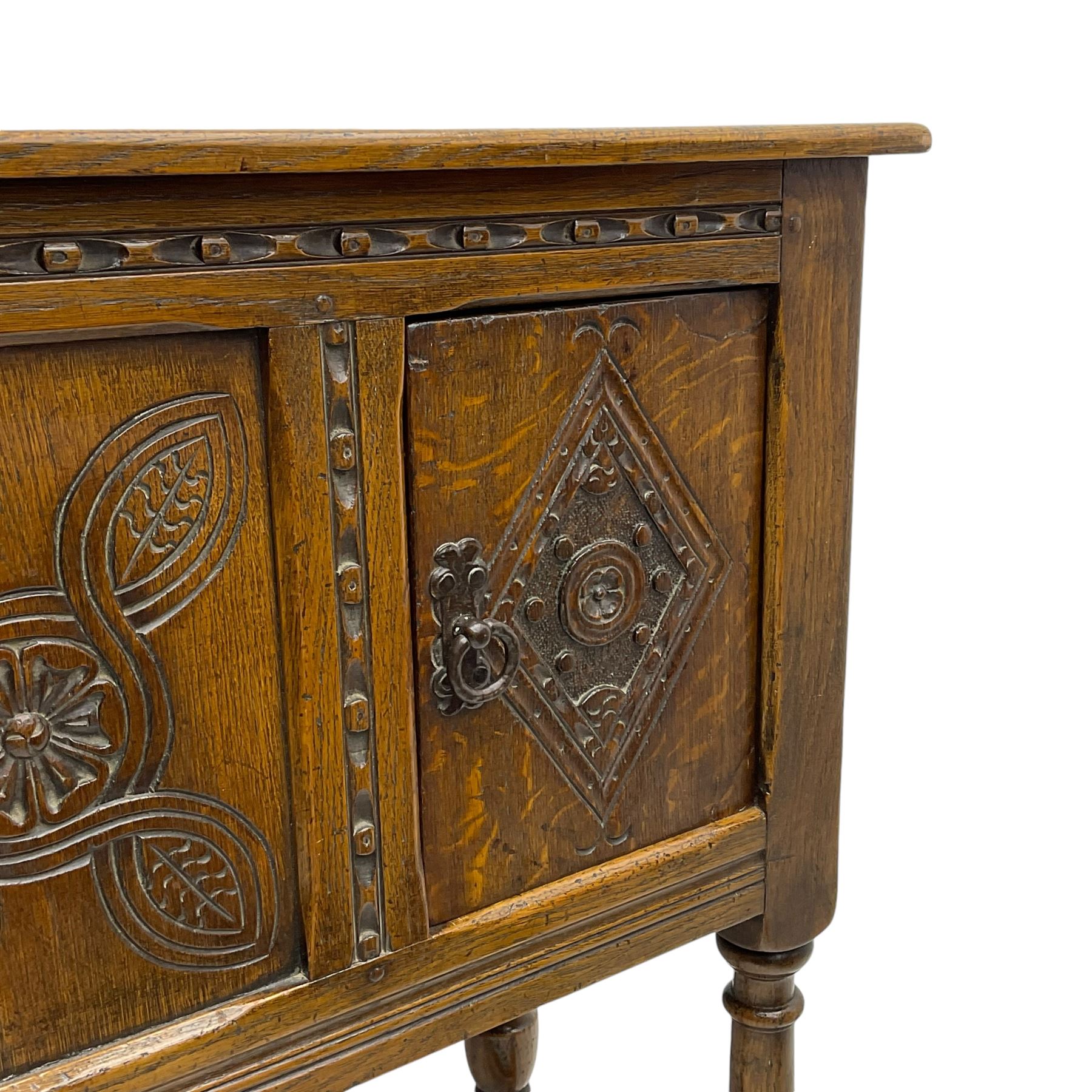 Jacobean design oak cupboard, rectangular top over two doors and central panel, carved with interlacing design with flower head and lozenges, on turned supports united by H-stretchers 