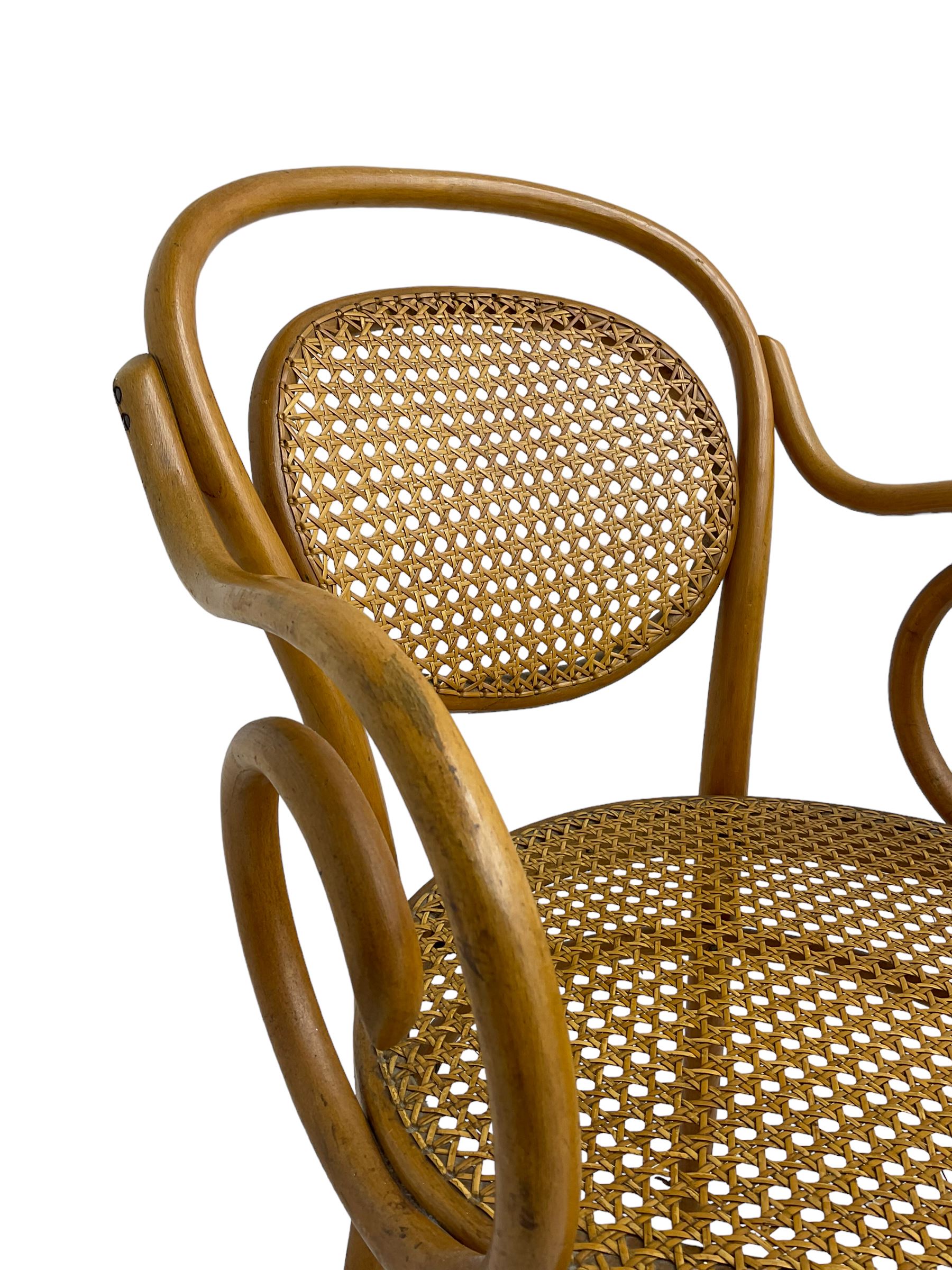 After Michael Thonet - bentwood armchair, circular cane seat and back, scrolled arms