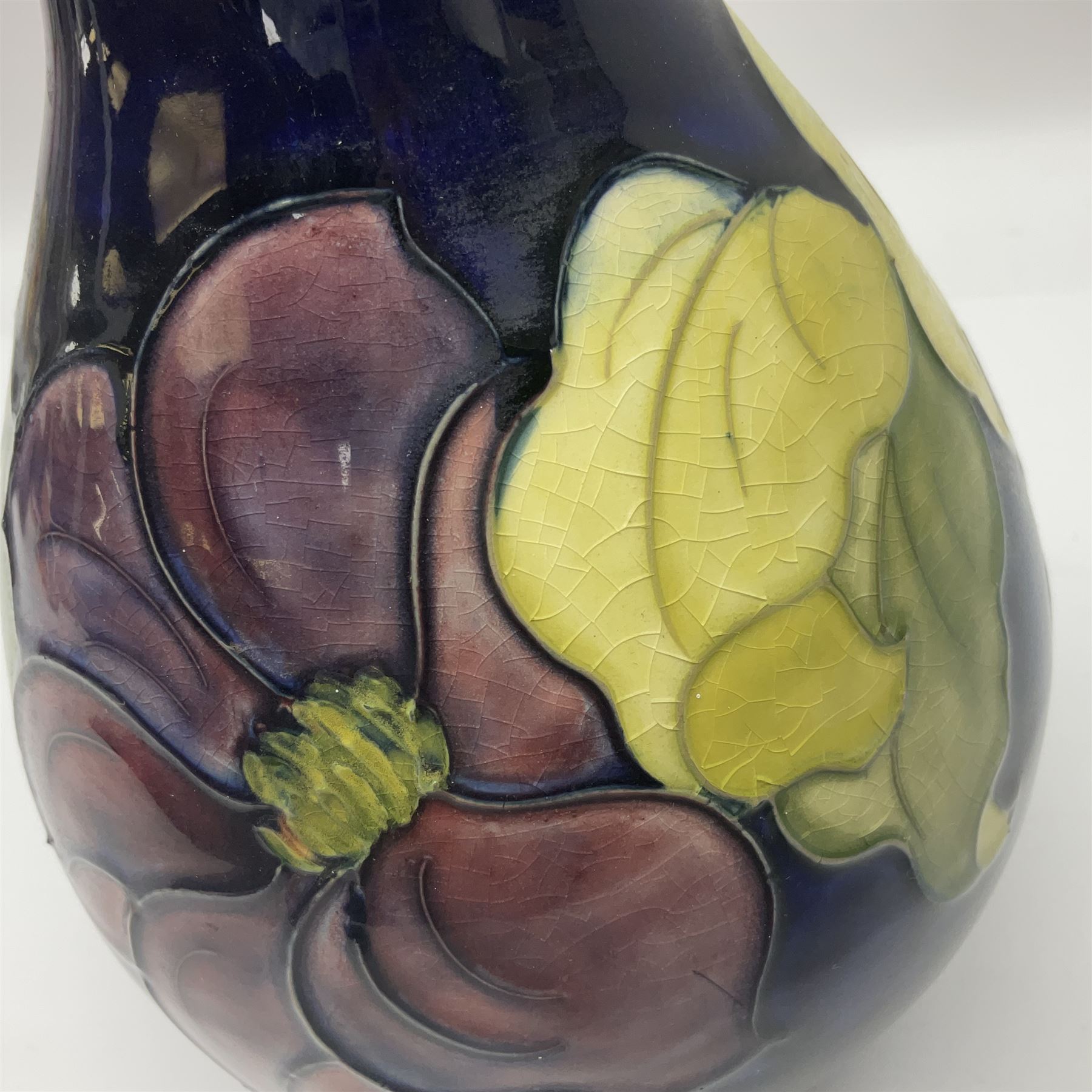 Moorcroft Clematis pattern vase of baluster form, upon a blue ground, with painted and impressed marks beneath, H22cm