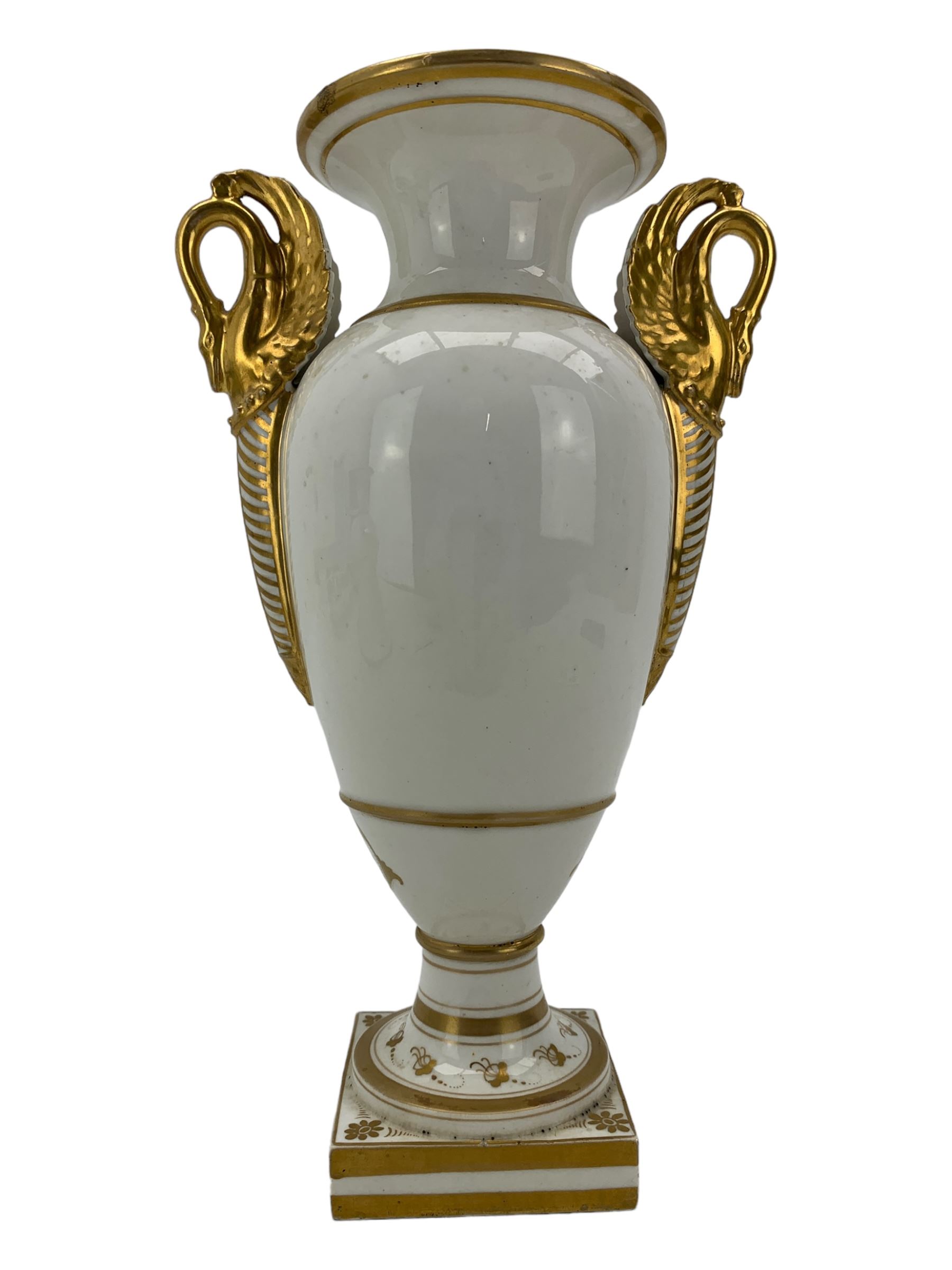 Early 19th century Derby vase, of campana urn form, decorated to one side with a hand painted reserve of a basket of flowers, within a scroll gilt border and twin serpent form handles, H20.5cm together with a Bloor Derby vase, hand painted with figures in a wooded landscape, with twin gilt swan form handles, upon a square pedestal foot, H25cm (2)