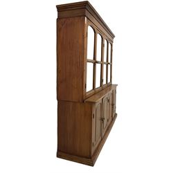 Mid-to-late 20th century Burmese teak wall cabinet, four glazed doors over four panelled doors, on moulded plinth base 