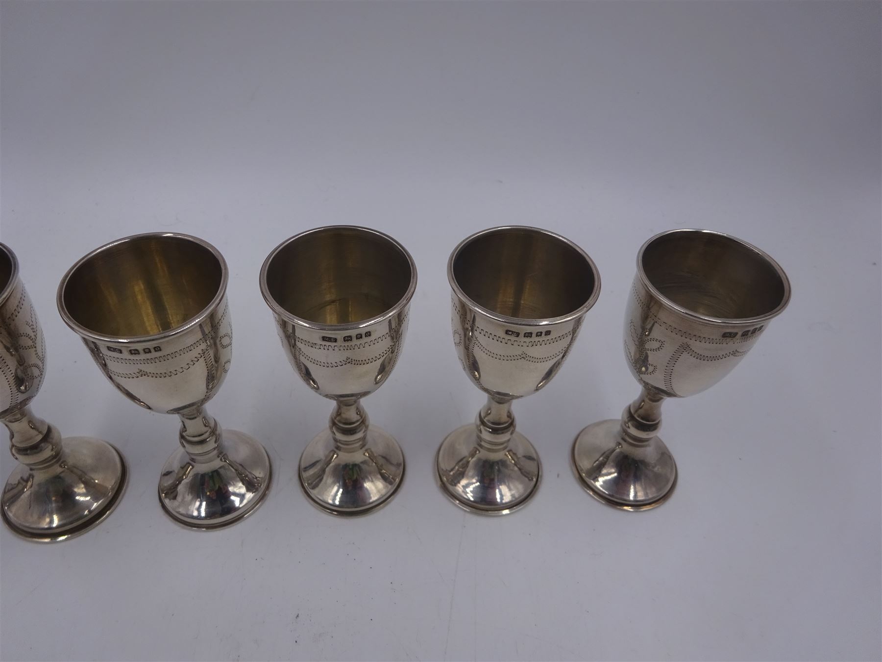 Set of six 1920s silver Kiddush cups, of goblet form with knopped stem, and engraved foliate detail, hallmarked London 1929, maker's mark M.S, H9cm