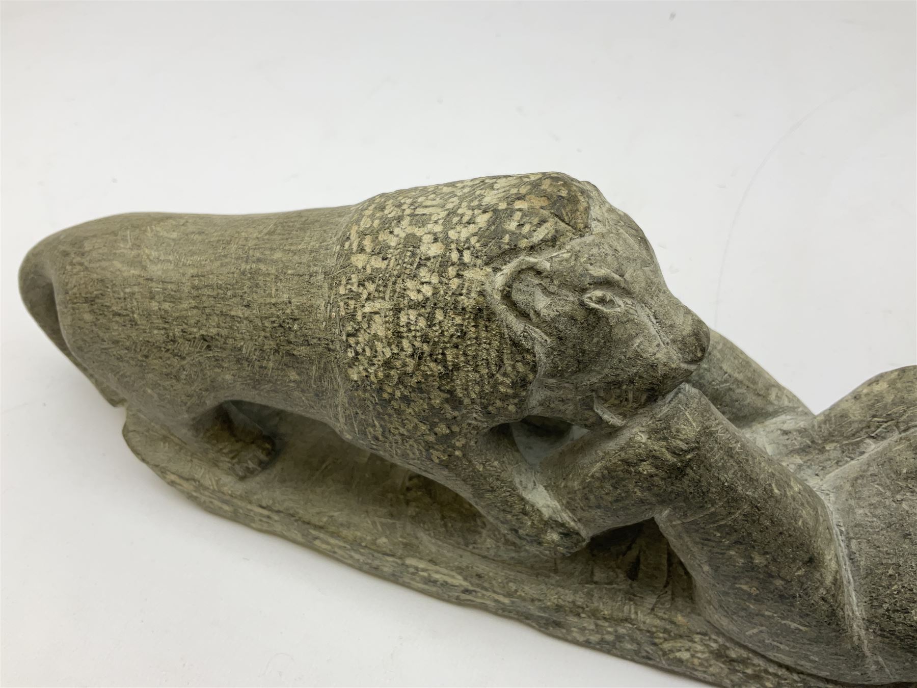 Carved stone sculpture of a figure group of a man and lion, H12cm, L32cm