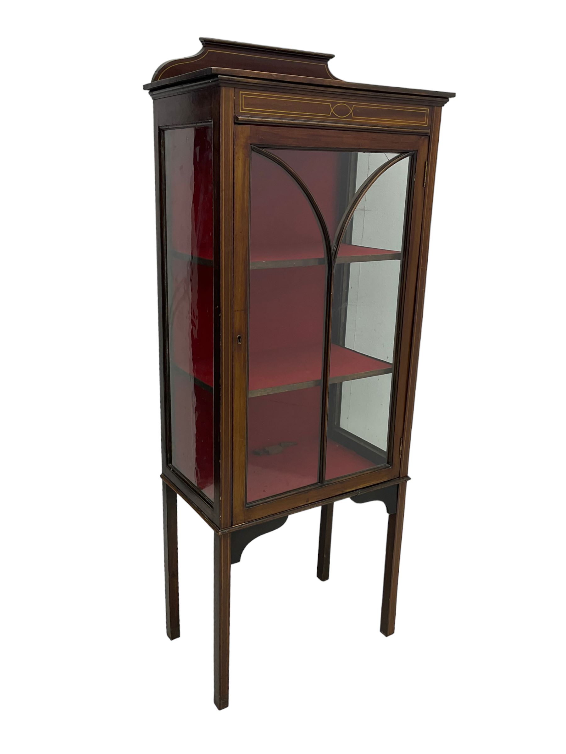 Early 20th century mahogany display cabinet, projecting moulded cornice over inlaid frieze, single astragal glazed door opening to reveal three felt-lined shelves, raised on square tapering supports