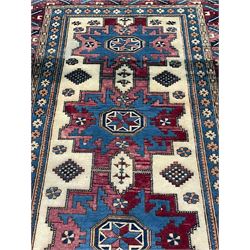 Turkish camel ground rug, three medallions surrounded by geometric motifs, the border decorated with stylised leaf motifs