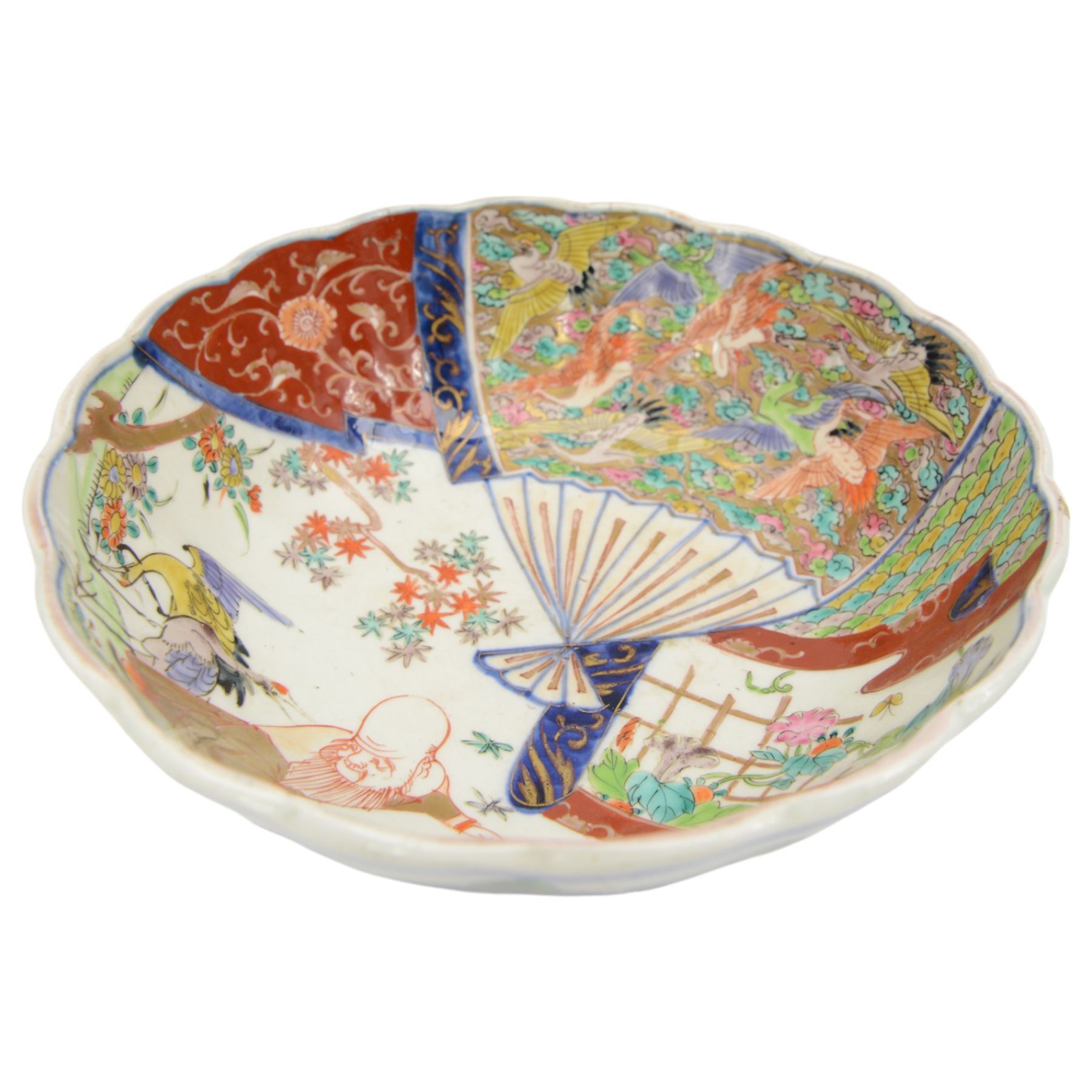 19th century/ early 20th century Chinese Canton blue and white bowl, centrally decorated with a landscape scene, within a famille rose enamelled border and scalloped rim, D26cm together with a Japanese Meiji Imari fluted bowl, decorated cranes, fans and scholar, D24cm (2)