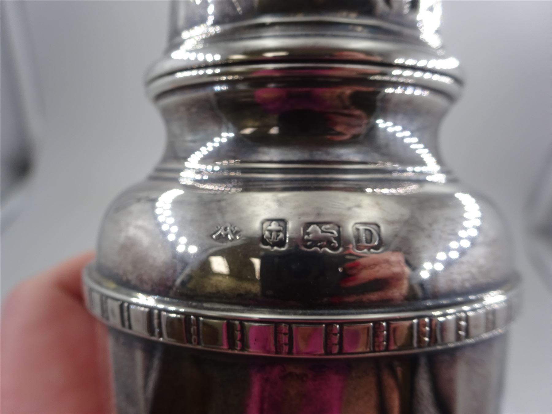 1920s silver sugar caster, of typical form with faceted body and pierced floral cover, upon stepped circular foot, hallmarked Adie Bros, Birmingham 1928, H20cm