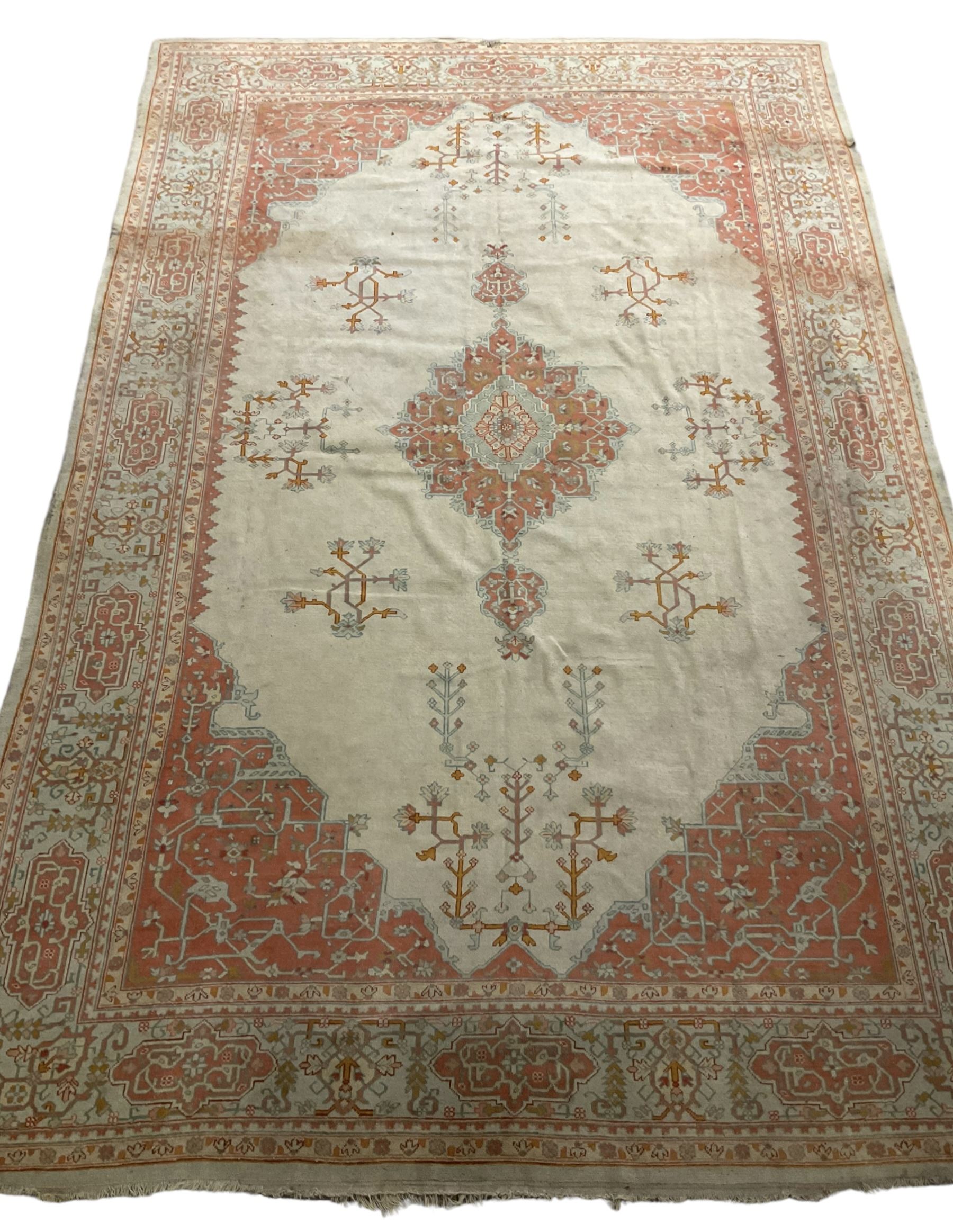 Large Persian pale sage ground carpet, the field decorated with central geometric medallion and tree of life motifs, the border with repeating geometric design decorated with stylised plant motifs