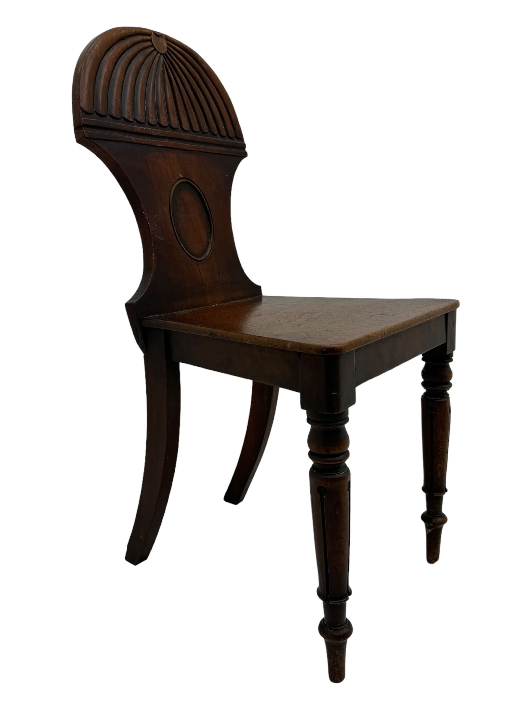 Regency mahogany hall chair, the carved back with shell motif and oval medallion, supported by turned front legs and splayed rear legs