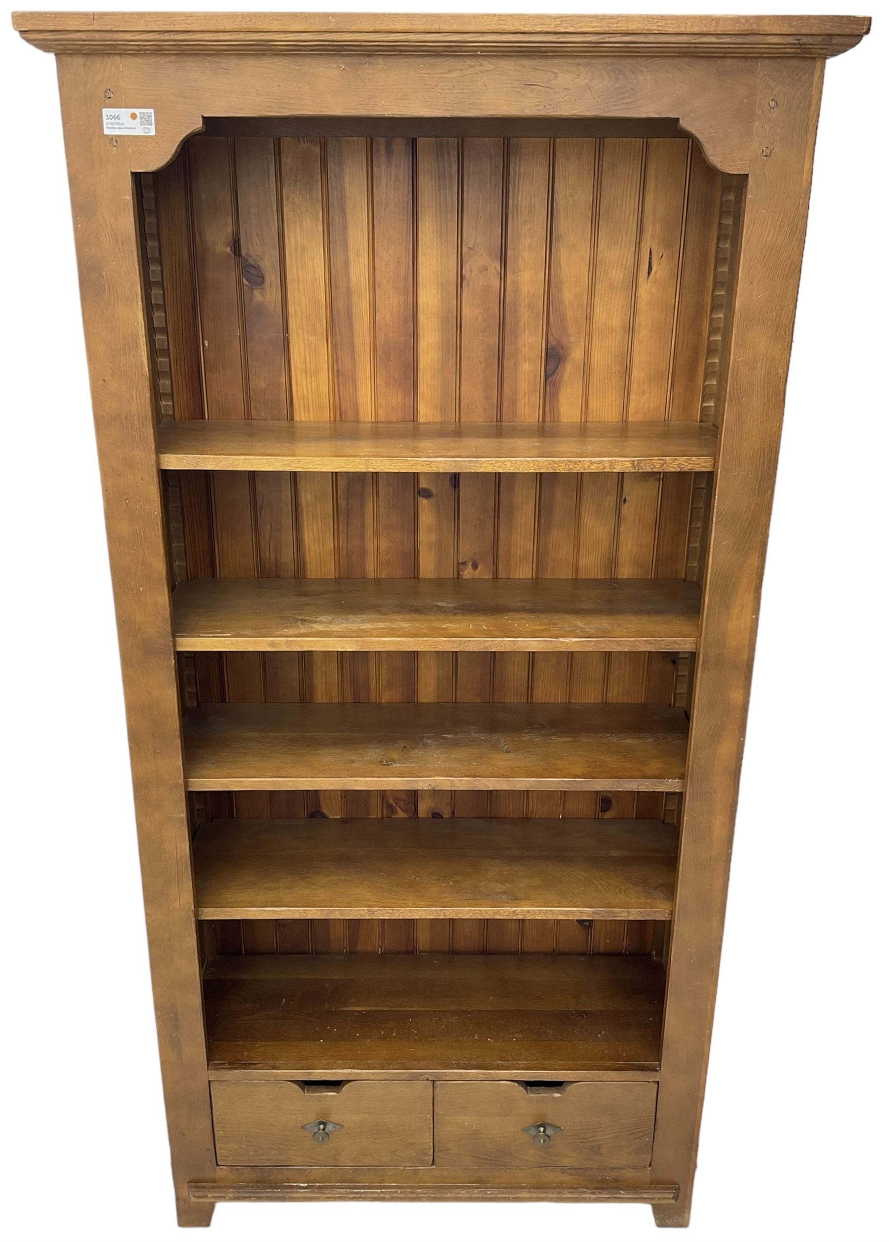 John Lewis - 'Bergerac' oak bookcase, projecting moulded cornice over four adjustable open shelves, two drawers to the base with cut-out handles, on square tapered supports