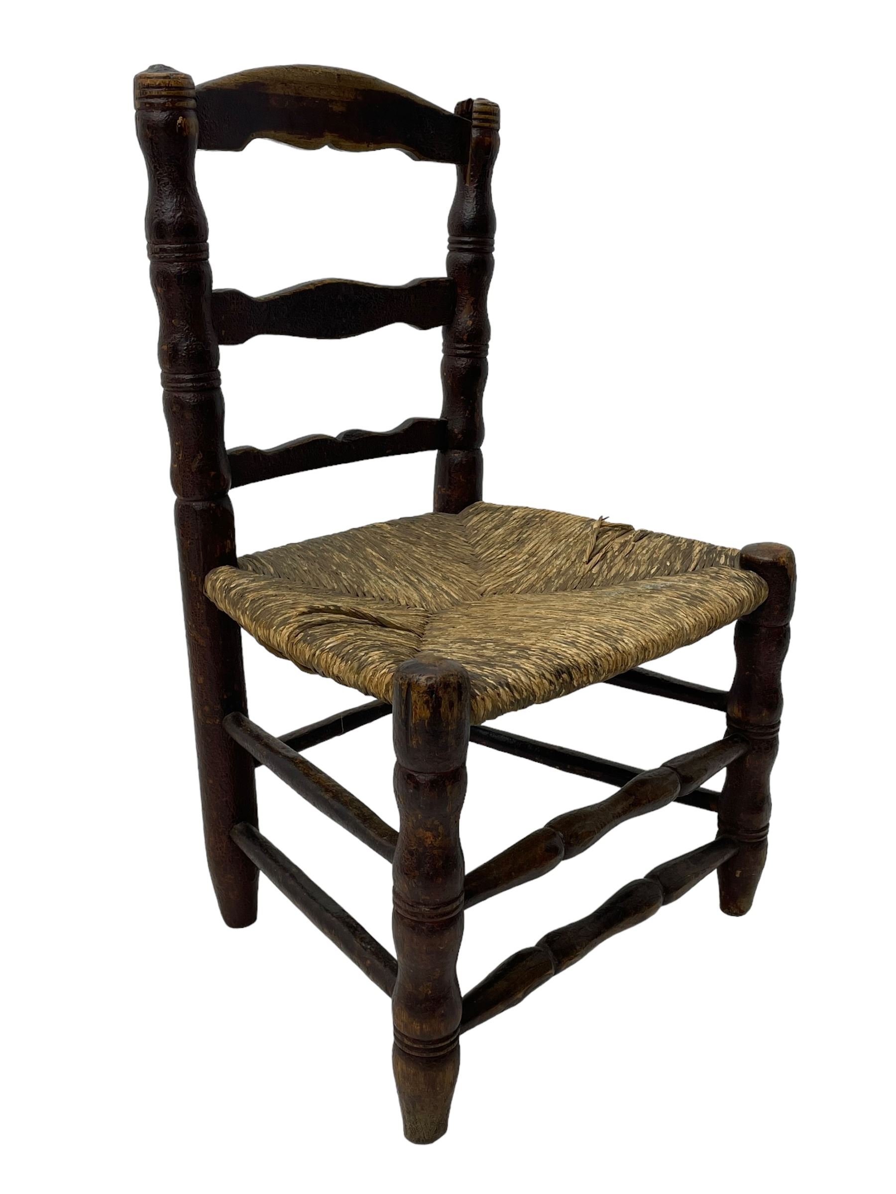 19th century painted elm primitive fire side chair, ladder back over rush seat, on turned supports united by turned stretchers 