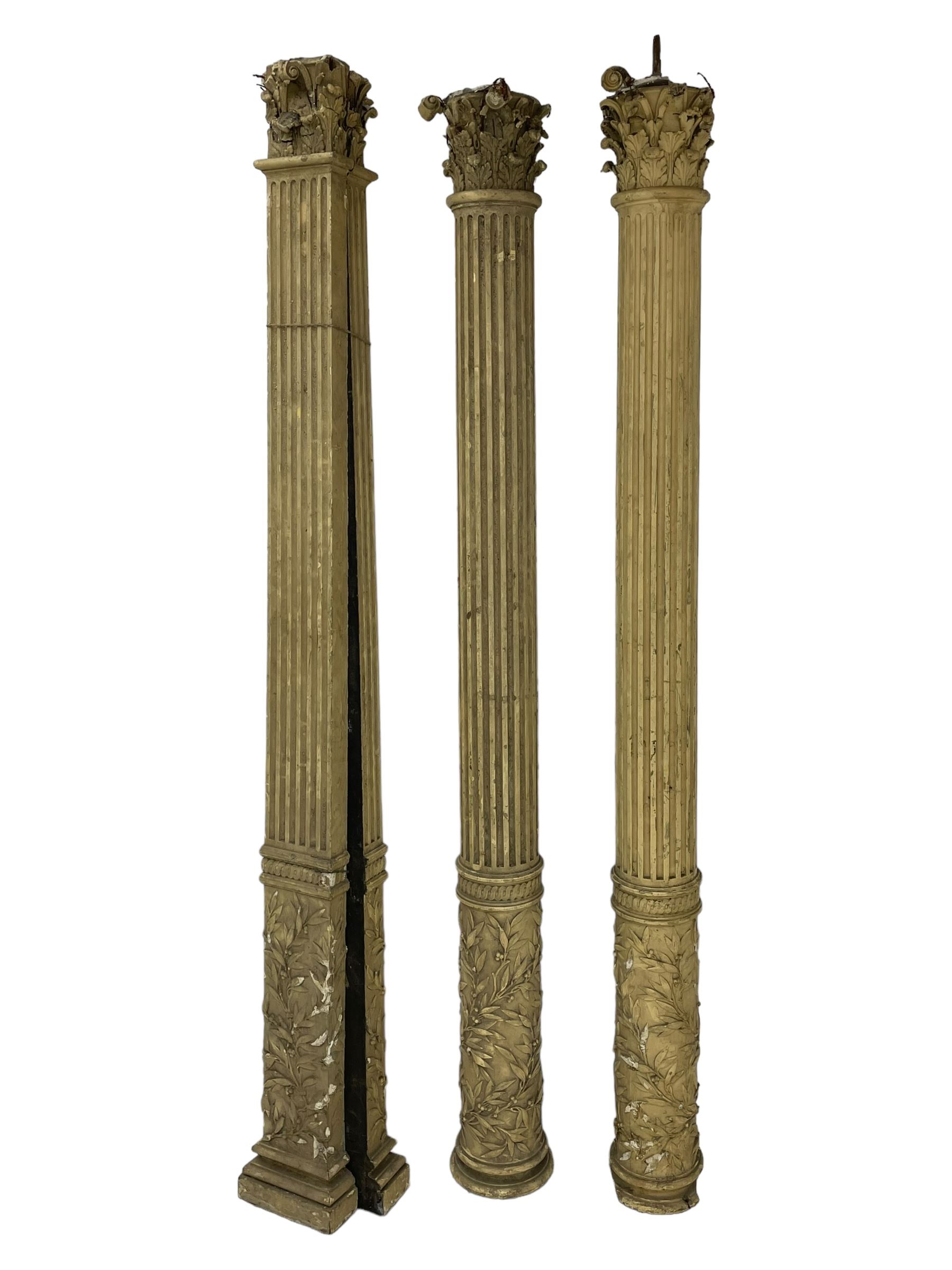 Three 19th century wood and gesso Composite order architectural architraves - curled acanthus leaf capitals over fluted shafts, the bases decorated with guilloche moulding over trailing laurel leaf branches, one half columns, one L-shaped rectangular pilaster and one full column, the largest - H204cm