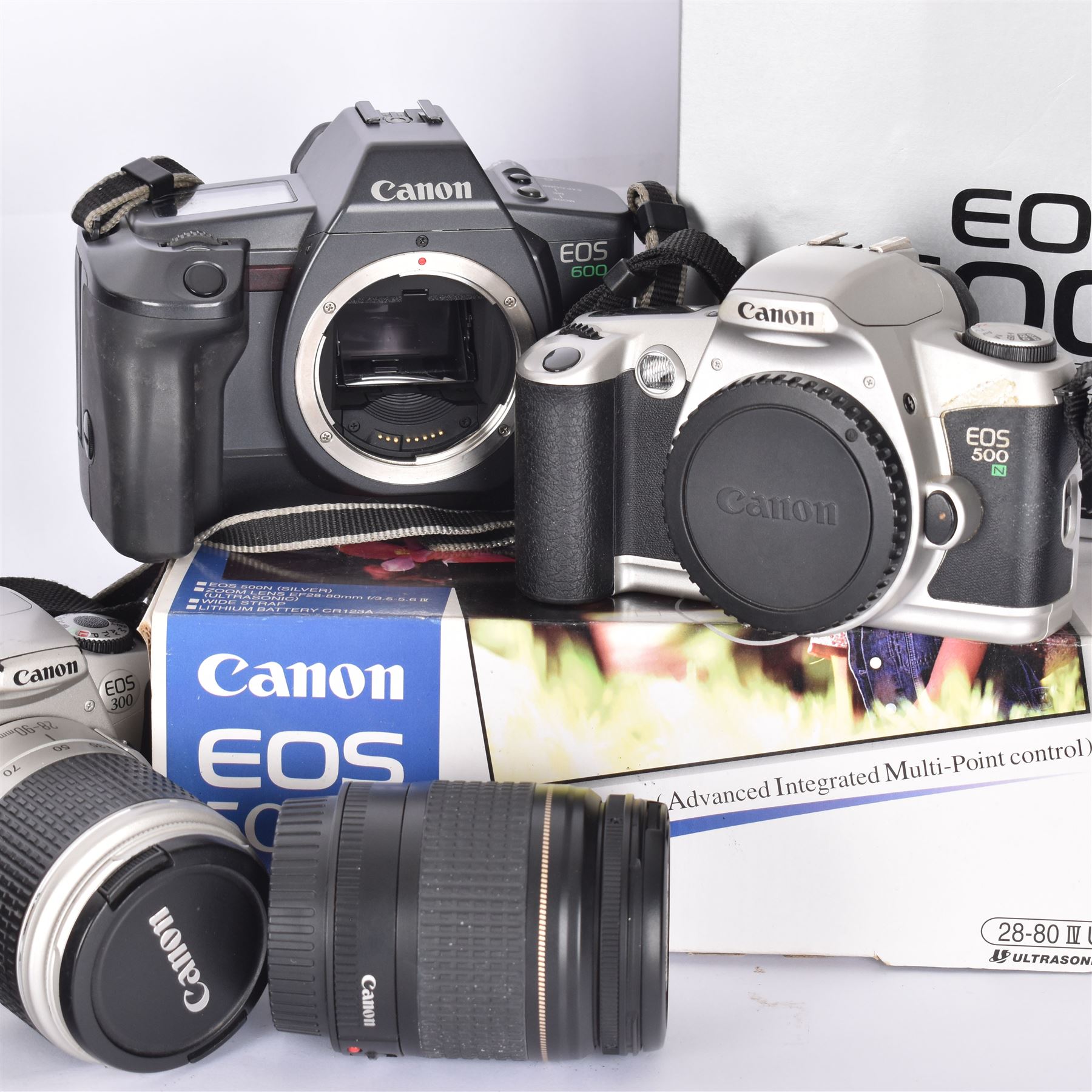 Three Canon EOS cameras, comprising EOS 500N Silver Kit, serial no. 9660130 with Canon EF 28-80mm 1:3.5-5.6 IV zoom lens, serial no. 9505171, EOS 300 with Canon EF 28-90mm 1:4-5.6 zoom lens, serial no. 5828460, and a Sigma 28-300mm 1:3.5-6.3 macro zoom lens, serial no. 1027931 and an EOS 600 camera body, serial no. 2651130, two boxed and one in carry case