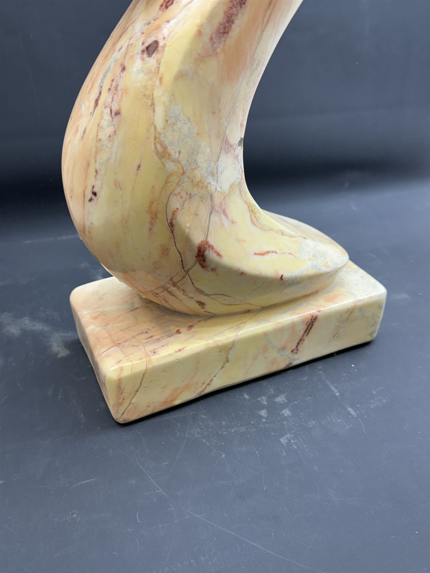 Abstract marble sculpture modelled as a mother and child on a rectangular base, H62cm