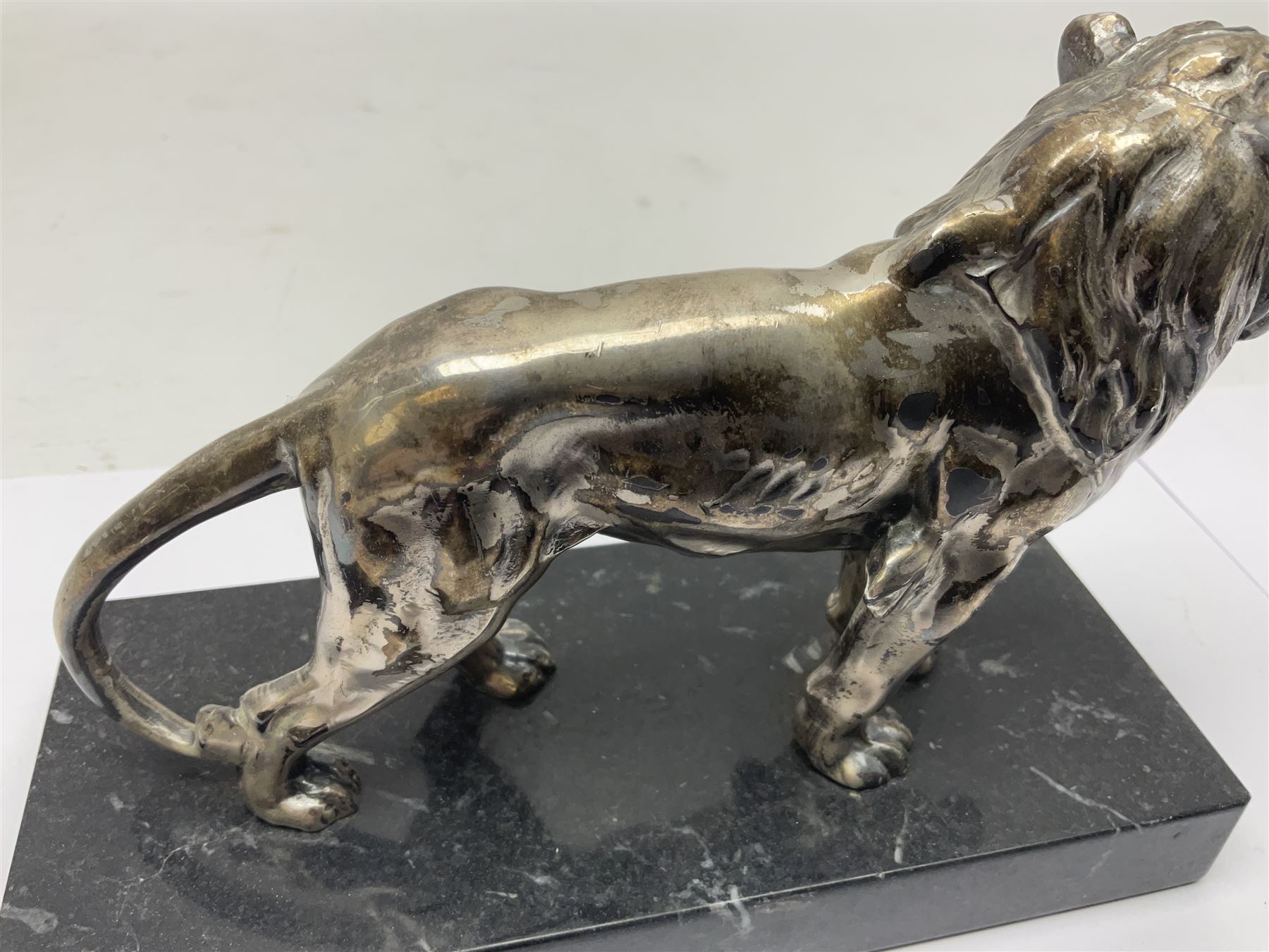 Silvered metal lion, upon a rectangular base, H12cm