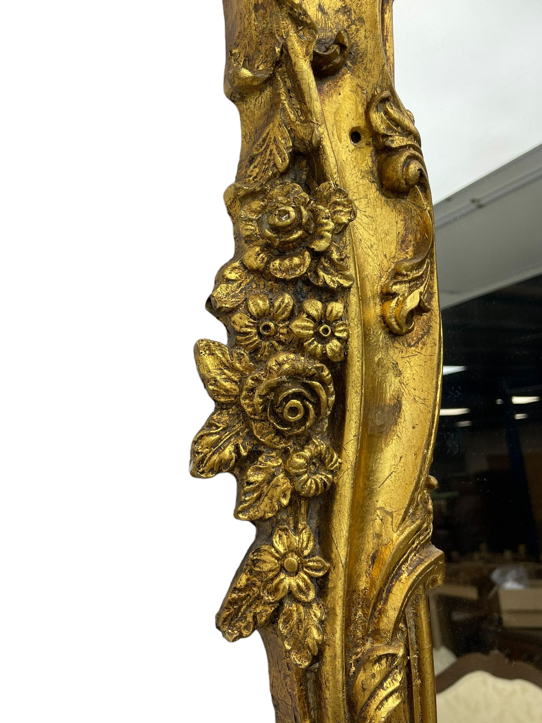 Large gilt framed rectangular wall mirror, shaped and moulded frame decorated with trailing curled acanthus leaves and flower head motifs, bevelled glass plate 